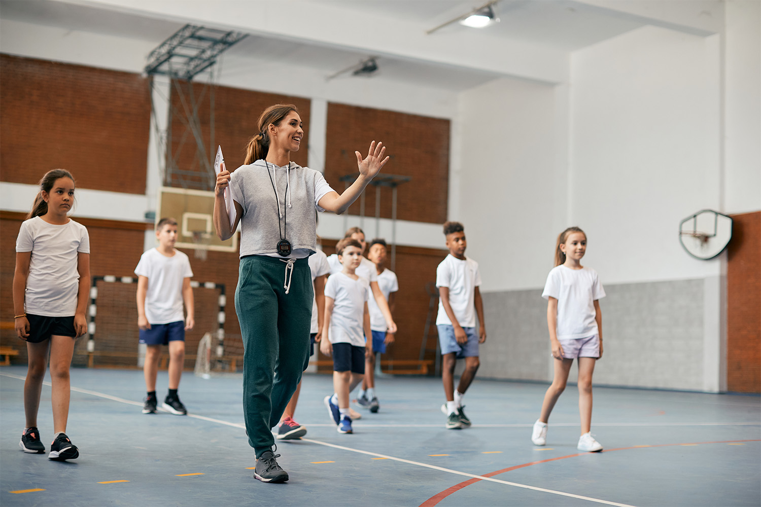 pe teacher teaching students in a hall