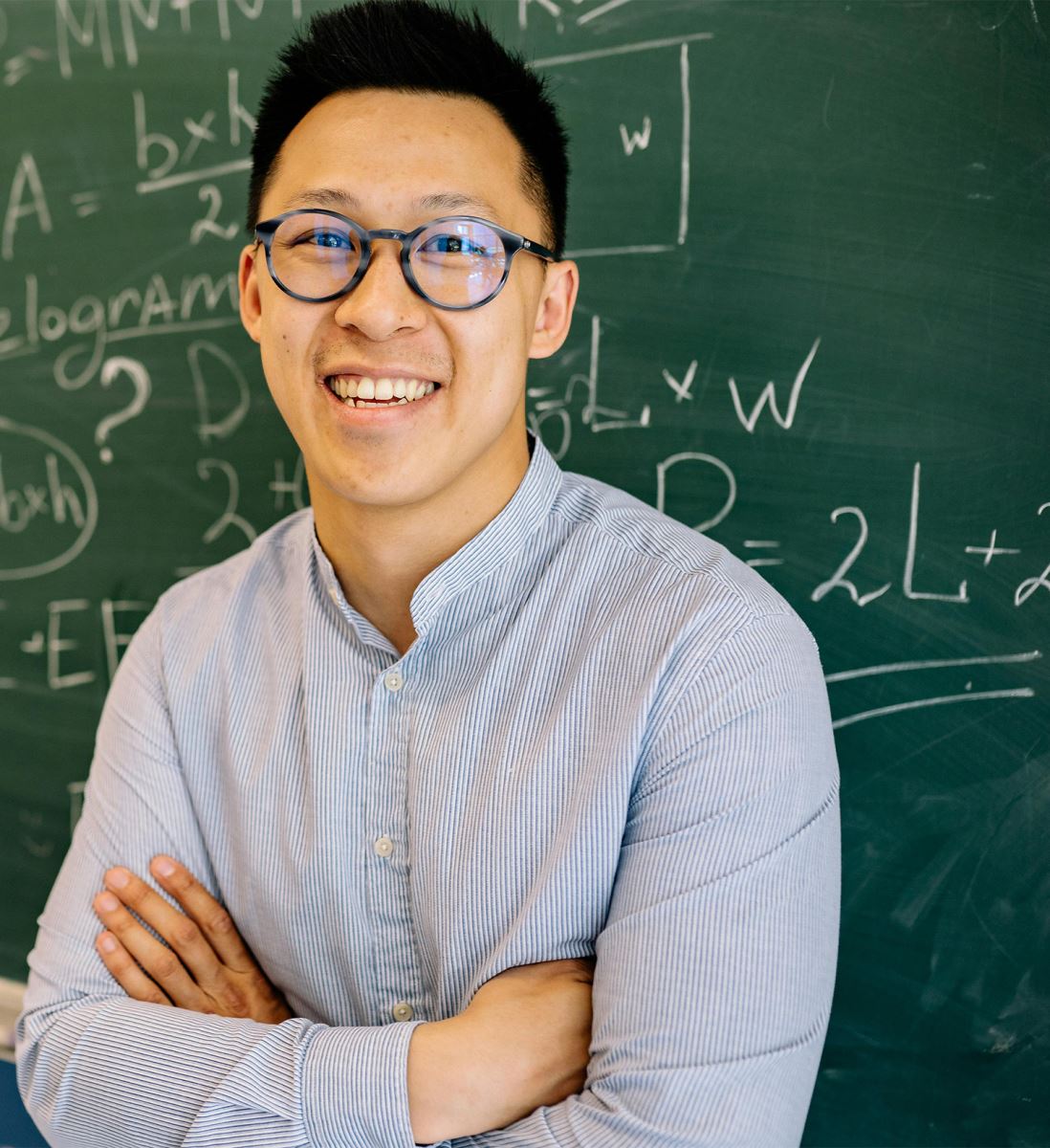 photo of teacher standing in front of a blackboard